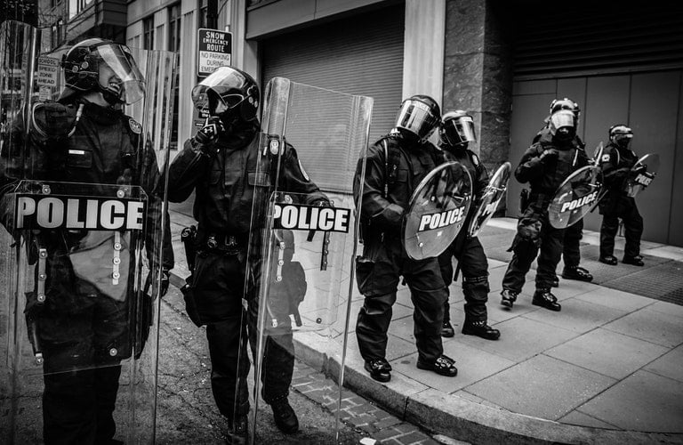 A Photo Of A Group Of Policeman Laughing In Full Riot Gear